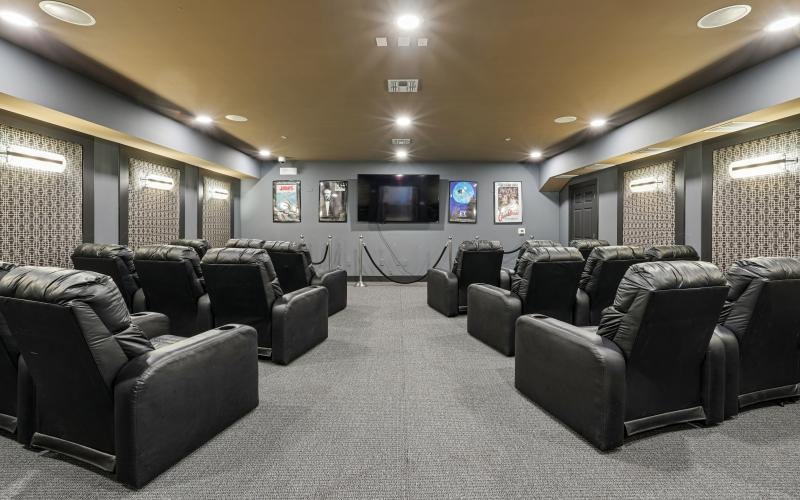 a theater room with a tv and chairs